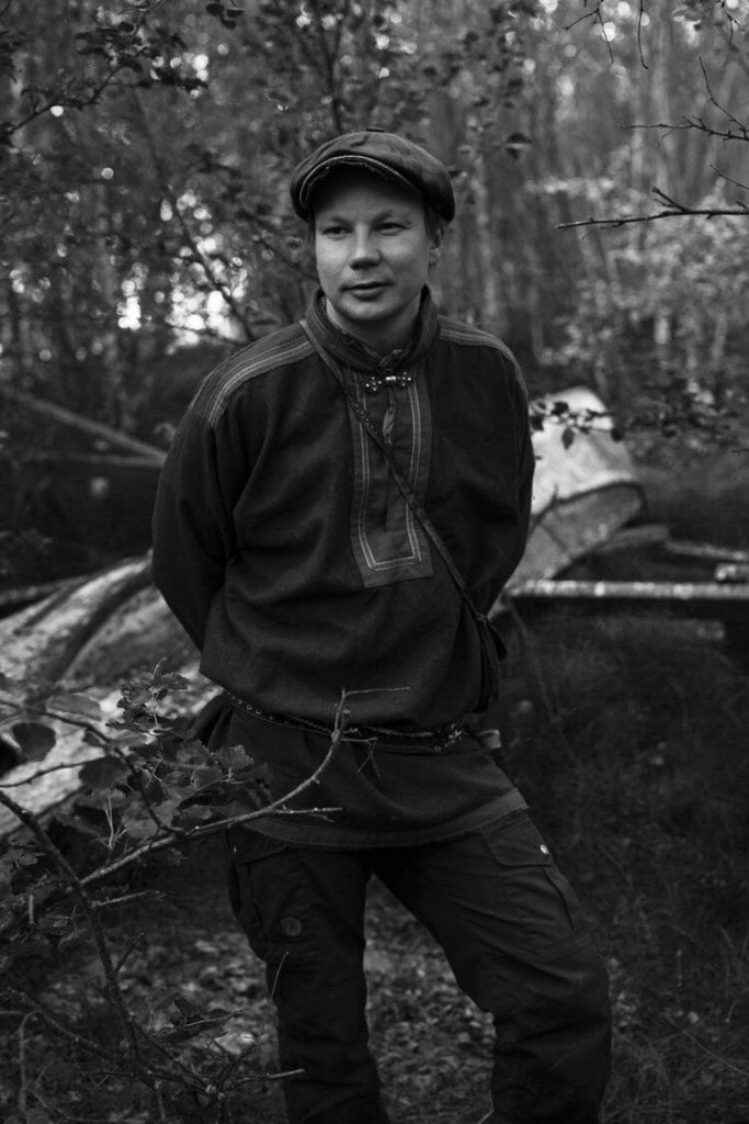 Mustavalkoinen kuva Niillas Holmbergista metsässä.