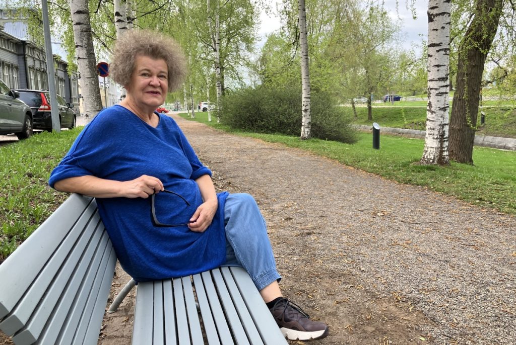 Marja-Riitta Vainikkala ulkona puistonpenkillä.