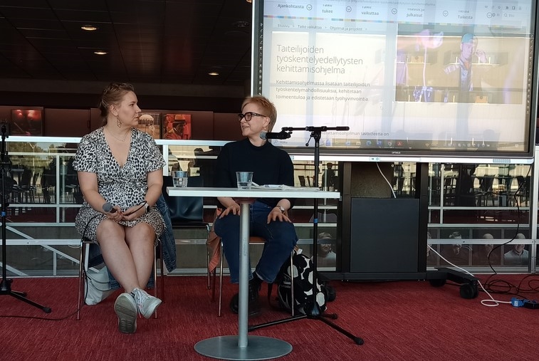 Dramaturgi Susanna Airaksinen ja ohjaaja Pia Peltola keskustelevat teatterin lämpiössä.