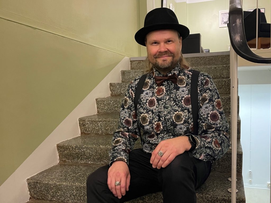 Tuomo Heikkinen istuu kirjallisuuden talon portailla.